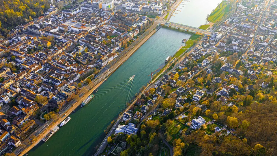 Ein Luftbild einer charmanten Stadt am Fluss mit Booten und Grünflächen.